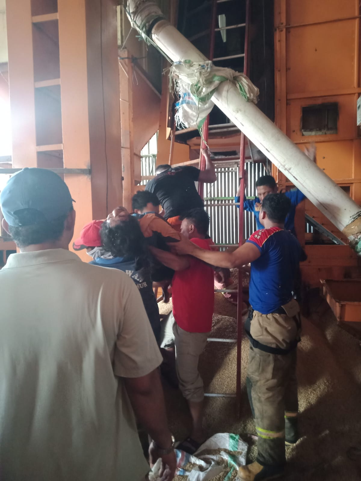 Personil Pemadam kebakaran Mengevakuasi salah seorang pekerja gudang yang pingsan akibat kebakaran Dryer di gudang pabrik padi desa Patengko, Selasa (07/06/22).